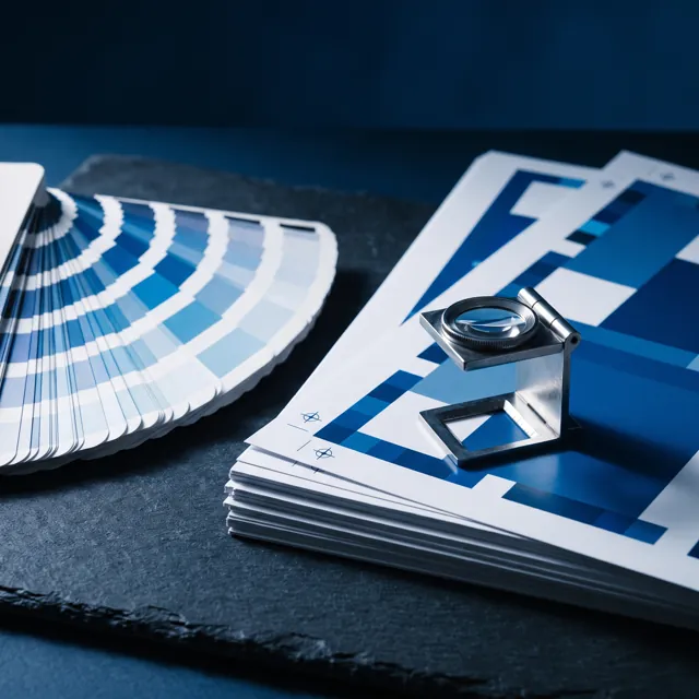 Colour proof sheets, an ink swatch fan and a loupe over registration marks