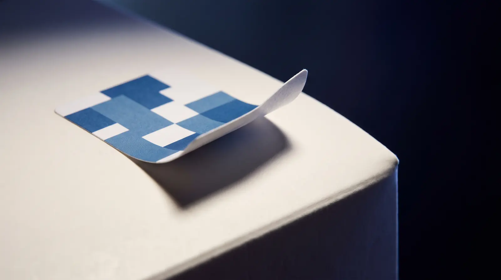 A removable paper label lifting cleanly from a carton, leaving no residue